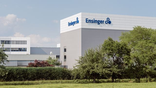 Ensinger headquarters in Nufringen with company logo and surrounding greenery.